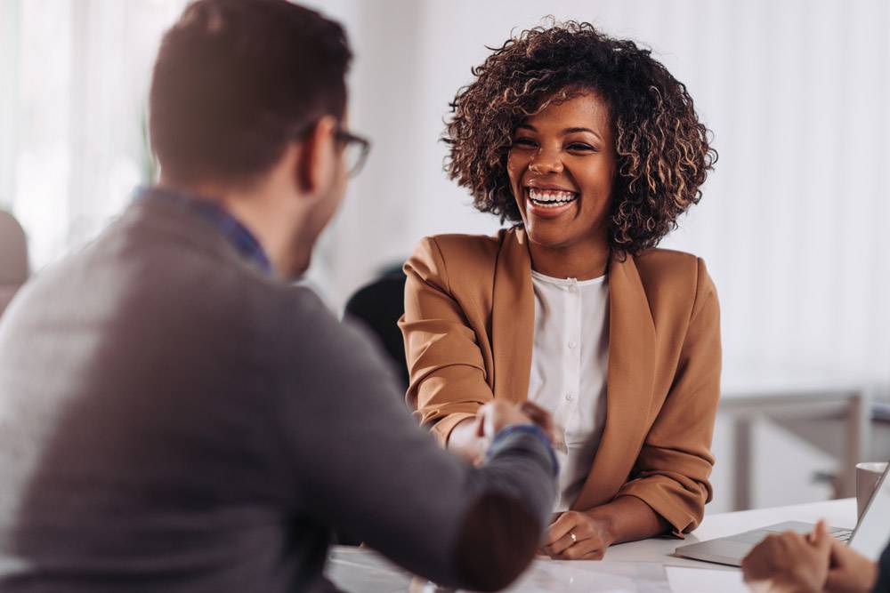 woman shaking hand of hiring manager