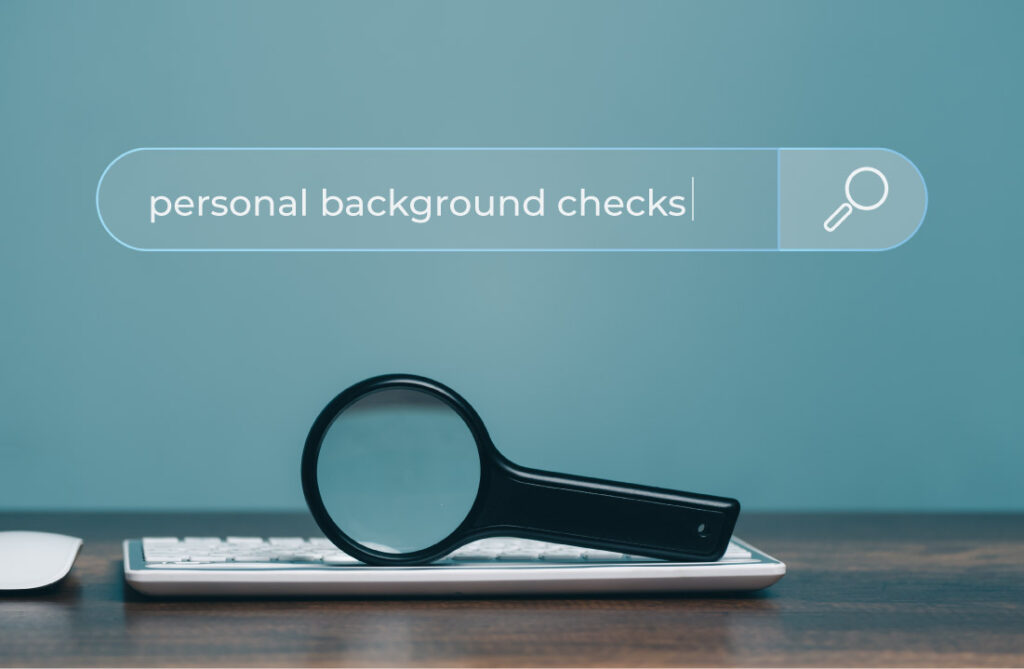 search bar against blue wall that says "personal background checks." Magnifying glass and keyboard below.