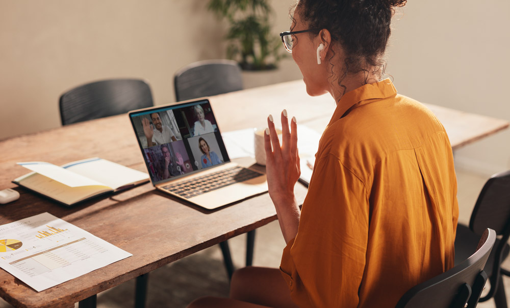 woman at home office, having video conference with co-workers.
