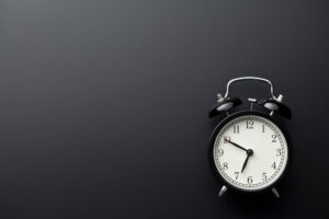 Alarm clock behind dark background. Turnaround time concept.