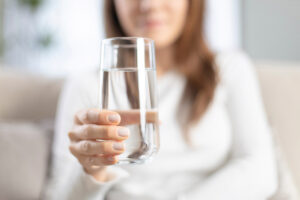 Female holding a glass of water.