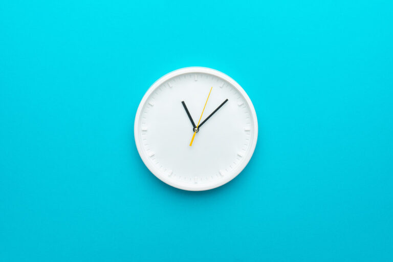 White clock against blue background.