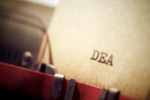 The letters "DEA" typed out on typewriter
